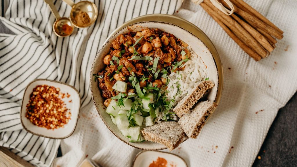 Tavola con piatto di curry vegan di ceci e pane